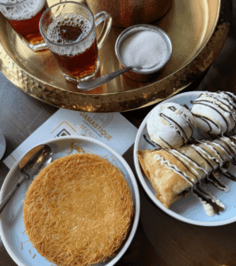 Traditional Syrian desserts including kunafa and baklava served with Arabic tea