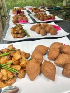 Halal kibbeh served with spiced roasted potatoes and green chillies on platters at a catering event