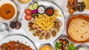 Halal Middle Eastern food platter with shawarma wraps, fries, dips, flatbread, grilled meat and fresh salad