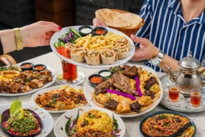 Middle Eastern restaurant food platter with grilled meats, wraps, chips, salads and traditional tea service.